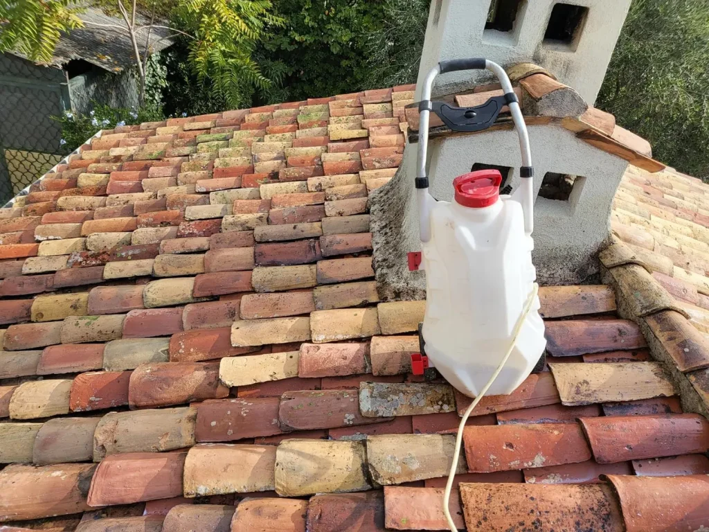 Pulvérisateur de traitement sur une toiture en tuiles à Grasse